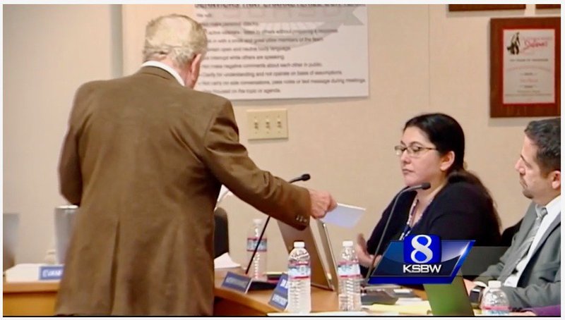 Rick Giffin serves Salinas Union High School District board member Kathryn Ramirez with recall papers.